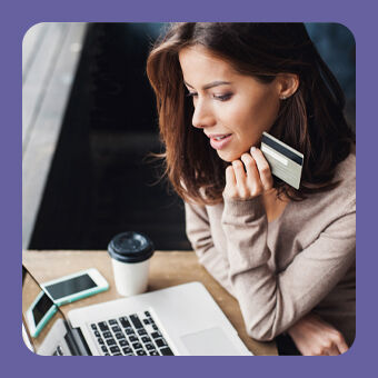 Person nutzt Laptop für Online-Shopping und hält Kreditkarte; moderner E-Commerce und sichere digitale Zahlung.