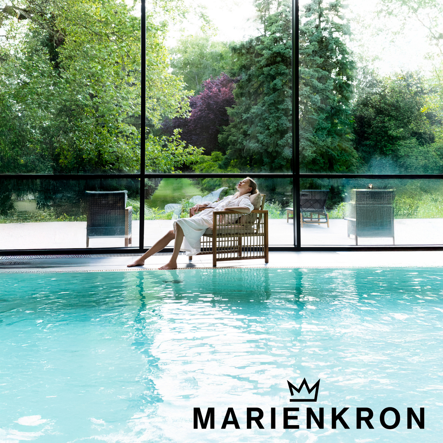 Person entspannt im Bademantel am Indoor‑Pool eines Marienkron Wellness‑Resorts, Fokus auf Ruhe, Erholung und exklusives Retreat‑Erlebnis