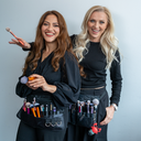 Zwei Make-up Artists in Schwarz mit Pinselgürteln vor neutralem Hintergrund – Beauty-Profis - Link zu Make-Up Artists