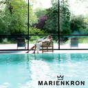 Person entspannt im Bademantel am Indoor‑Pool eines Marienkron Wellness‑Resorts, Fokus auf Ruhe, Erholung und exklusives Retreat‑Erlebnis