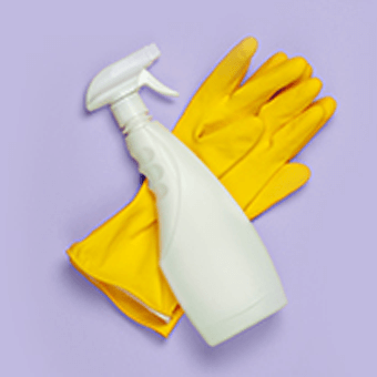 Weiße Putzflasche und gelbe Putzhandschuhe auf lila Hintergrund.