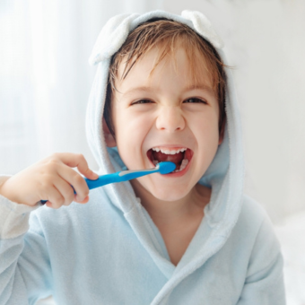 Kind im blauen Bademantel putzt Zähne mit blauer Zahnbürste – Fokus auf Zahnpflege, Kinderhygiene und Morgenroutine.