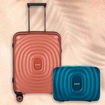 Zwei stylische Koffer auf Sand: großer oranger Trolley und kleiner blauer Koffer – Reisegepäck, Urlaub, Design