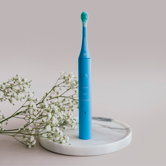 Blaue elektrische Zahnbürste auf Marmorsockel mit weißen Blumen – gründliche Zahnpflege, Design, Dentalhygiene