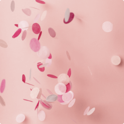 Rosa und pinkes Confetti vor rosa Hintergrund.