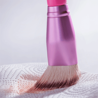 Make-up-Pinsel mit pinken Borsten & Metallic-Griff auf weißer Struktur – Beauty-Tool, Kosmetikzubehör, Schminkhilfe.