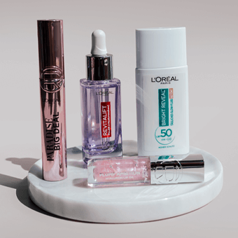 L'Oréal Sonnencreme, Revitalift Serum & Mascara – Beautyprodukte auf Marmor-Tablett