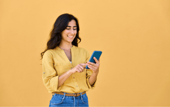Person mit gelber Bluse hält blaues Handy in der Hand. Copyright: Shutterstock