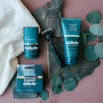 Gillette Intimate Rasurprodukte – Rasierer, Gel & Deo für sanfte Intimpflege, präsentiert mit Eukalyptus auf Stein.