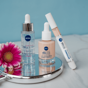 NIVEA CELLULAR FILLER Serum, Foundation & Concealer – Anti-Aging Pflegeprodukte auf Spiegel mit Blume