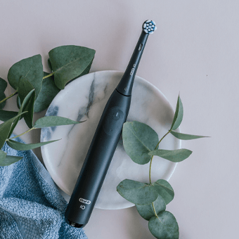 Oral-B elektrische Zahnbürste auf Marmorteller mit Eukalyptus – moderne Zahnpflege für gesunde Zähne