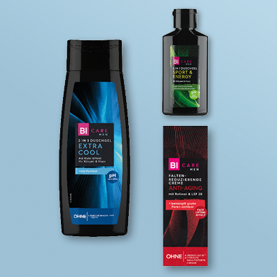 Männerpflege: Duschgel und Creme in schwarzer Verpackung mit farbigen Etiketten auf hellblauem Hintergrund.