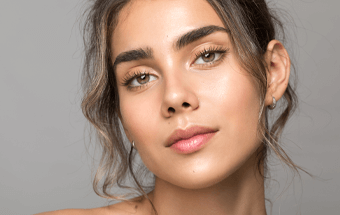 Zeigt eine geschminkte Frau mit definierten Augenbrauen - Link zu Blogartikel Augenbrauenschminken