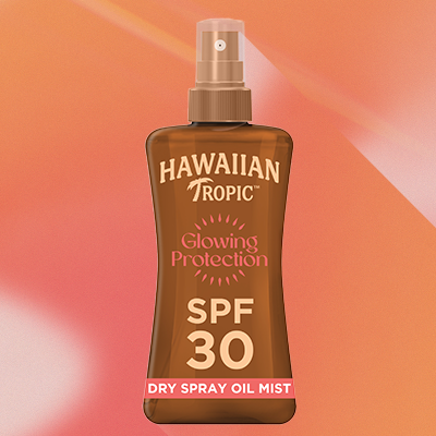 Hawaiian Tropic Glowing Protection SPF 30 Dry Spray Oil Mist vor orangefarbenem Farbverlauf – sommerlicher Sonnenschutz