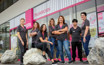 Gruppe von sieben Personen vor BIPA-Filiale – Symbol für Vielfalt, Inklusion und Teamkultur im Unternehmen