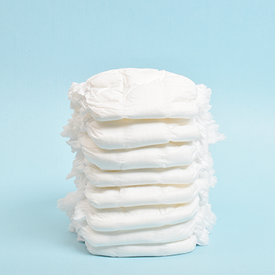 Stapel weißer Babywindeln auf hellblauem Hintergrund – Monatsvorrat für Babys, saugstark und bequem.