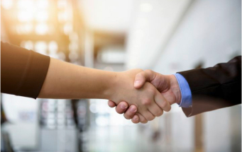 Händeschütteln im Büro – Symbol für Fairness, soziale Verantwortung und ethische Produktionsstandards.