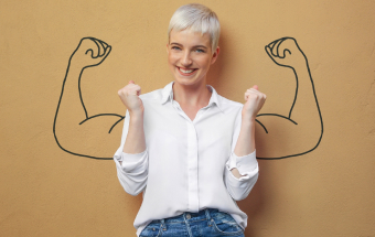 Person zeigt Muskeln mit gezeichneten Muskelarmen – Symbol für Gesundheitsförderung und Aufklärung