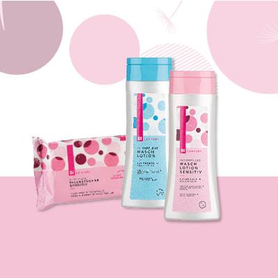Drei Hautpflegeprodukte mit rosa und blauer Verpackung – Reinigungstücher und Lotion auf rosa Hintergrund.