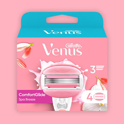 Venus Ersatzklingen –Frau sitzt im Badezimmer und rasiert sich die Beine