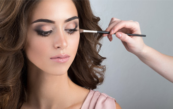 Person erhält ein präzises Augen‑Make‑up mit Pinsel – Tutorial zu Cut‑Crease‑Technik und professioneller Beauty‑Anwendung.