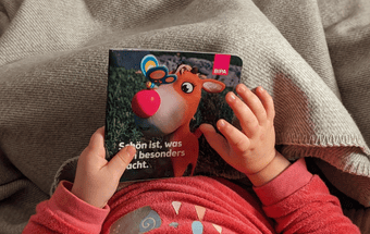 Kind hält Kinderbuch in den Händen. Copyright: BIPA