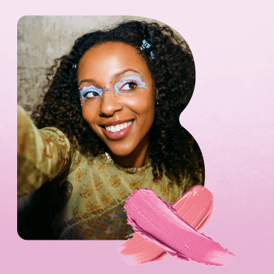 Beauty‑Motiv mit lockigem Haar, rosa Hintergrund und Make‑up‑Pinselstrichen als Symbol für Pflege und Make‑up.