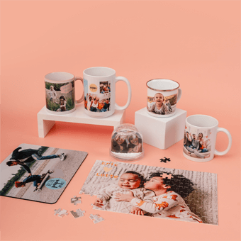 Personalisierte Fotogeschenke wie Tassen, Puzzles & Schneekugeln mit Familienfotos auf rosa Hintergrund