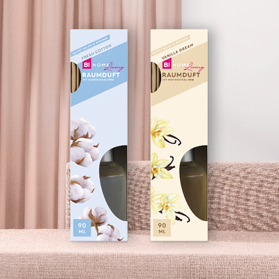 BI Home Living Raumdüfte vor beigen Vorhängen und Sofa.