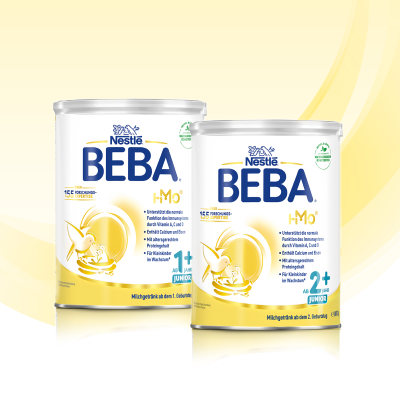 Nestlé BEBA Kindermilch – altersgerechte Milch für Kleinkinder, Kind trinkt aus Becher mit Geschwister im Hintergrund