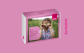 BIPA Geschenkbox mit Frühlingsmotiv: Kind hält zwei Gänseblümchen vor die Augen, farbenfrohe Verpackung als Symbolbild.