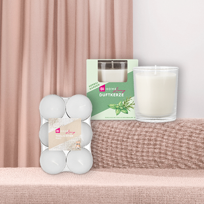 BI Home Living Kerzen vor beigen Vorhängen und Sofa.