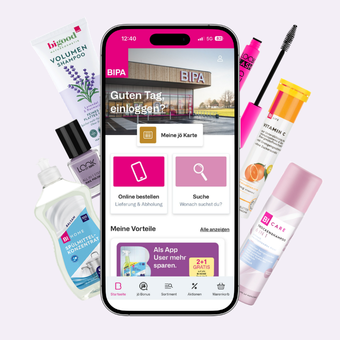 BIPA App auf Smartphone umgeben von Beauty- und Pflegeprodukten; Kombination aus Online-Service und Sortiment.