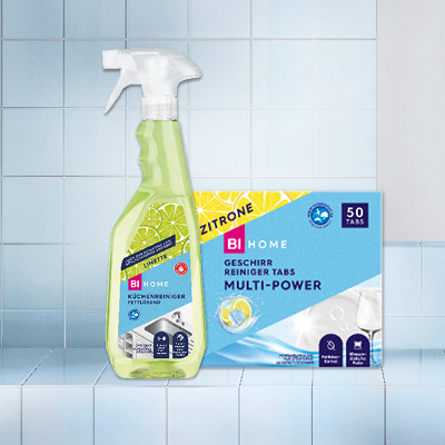 Zitronenreiniger-Spray & Multi-Power-Tücher vor blauem Fliesenspiegel – effektive Haushaltsreinigung leicht gemacht.