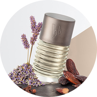Parfümflasche mit Lavendel und Tonkabohnen auf hellem Hintergrund, bb-Logo auf dem silbernen Verschluss.