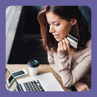 Person nutzt Laptop für Online-Shopping und hält Kreditkarte; moderner E-Commerce und sichere digitale Zahlung.