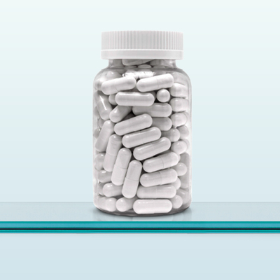 Eine durchsichtige Dose mit weißen Kapseln. 