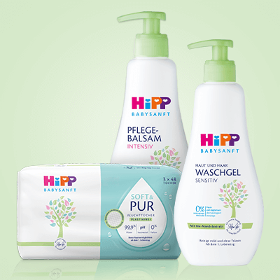 HiPP Babysanft Pflegebalsam, Sensitiv Waschgel & Soft Pur Feuchttücher vor grünem Hintergrund.