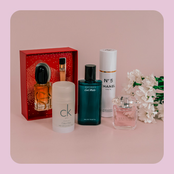 Verschiedene Parfums und Duftsets von Marken wie Chanel, Calvin Klein und Davidoff, dekorativ arrangiert neben Blumen.