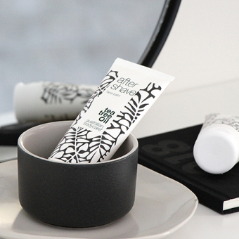 Rasiergel für Männer in stilvoller Tube im schwarzen Becher auf Badezimmerregal – sanfte Rasurpflege mit Teebaumöl. - Link zu Markenwelt/Rasur für Männer