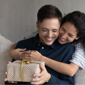 Zwei Personen tauschen Geschenke – Geschenkideen für besondere Anlässe, Pflege und Lifestyle. - Link zu Geschenke für Männer