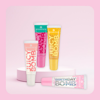 Essence Juicy Bomb Lipglosse und Birthday Bomb Lippenpflege auf Podest, farbige Tube für glänzende Lippen und Lippenpflege