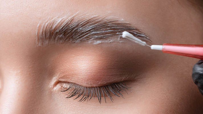 Brow‑Lifting‑Behandlung mit Bürstchen und Pflegecreme auf Augenbrauen, Beauty‑Routine für vollere, definierte Brauen.