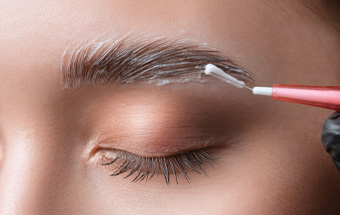 Nahaufnahme einer Brauenbehandlung mit aufgetragenem Brow‑Lifting‑Gel – Styling, Formgebung und Pflege der Augenbrauen.