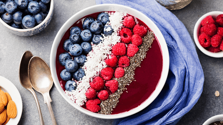 Smoothie Bowl mit Heidelbeeren, Himbeeren, Chiasamen und Kokosflocken – gesundes Frühstück, Superfood, vegane Ernährung