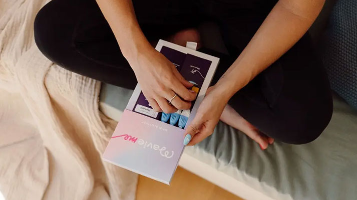 Person hält Mavie Zuhause‑Gesundheitstests in der Hand, Banner zu Gesundheitsanalyse, Laborcheck und Online‑Beratung