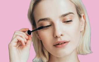 Person mit Blick nach unten trägt Wimperntusche auf. - Link zum Blogartikel so findest du die perfekte Wimperntusche