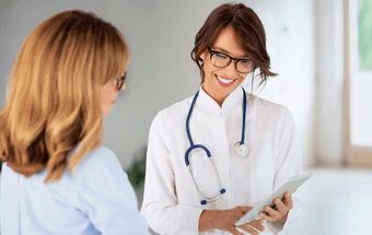 Medizinisches Beratungsgespräch: Fachkraft mit Stethoskop zeigt Patientin Informationen auf Tablet – Gesundheit, Diagnose. Copyright: Adobe Stock
