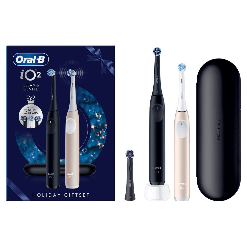 Oral-B iO 2 Holiday Geschenkset mit zwei Zahnbürsten und drei Aufsteckbürsten, dargestellt mit Reiseetui und Ladestation. [SV] Oral-B iO2 Holiday Giftset, inklusive två eltandborstar, tre borsthuvuden, ett resefodral och ett laddningsställ. [EN] Oral-B iO2 Holiday Giftset, including two toothbrushes, three brush heads and a travel case. [DA] Oral-B iO2 Holiday Giftset, der indeholder to elektriske tandbørster og tre børstehoveder. [IT] Oral-B iO2 Holiday Giftset con due spazzolini elettrici (nero e oro rosa), custodia da viaggio e tre testine di ricambio. [FI] Oral-B iO2 -joululahjapakkaus, jossa kaksi sähköhammasharjaa (musta ja vaalea), matkakotelo ja kolme harjaspäätä. [NO] Oral-B iO2 Holiday Giftset med to elektriske tannbørster og 3 børstehoder inkludert. [FR] Oral-B iO2 coffret cadeau comprenant deux brosses à dents, trois têtes de brosse et un étui de voyage. [NL] Oral-B iO2 tandenborstel holiday giftset, met twee tandenborstels en drie opzetborstels inbegrepen.;