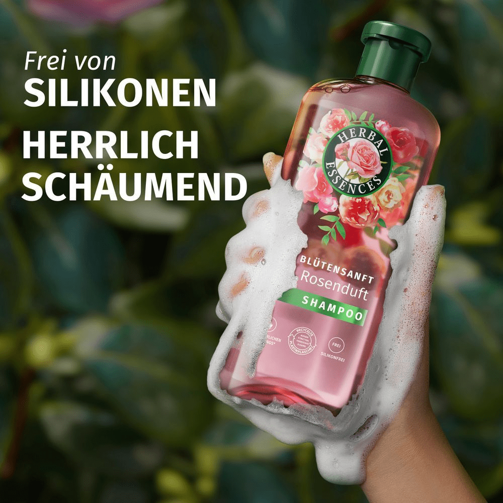 Herbal Essences Rosenduft Shampoo, umgeben von reichhaltigem Schaum, bewirbt die silikonfreie und herrlich schäumende Formel.